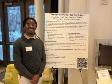 Dante Parker standing by his project, "Through Her Eyes (But Not Quite)."